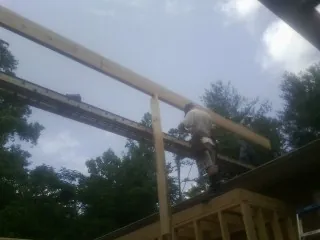 Carpenter setting a ridge beam over a new addition frame — Ice Dam Removal by Roofing Brothers in Fort Rock