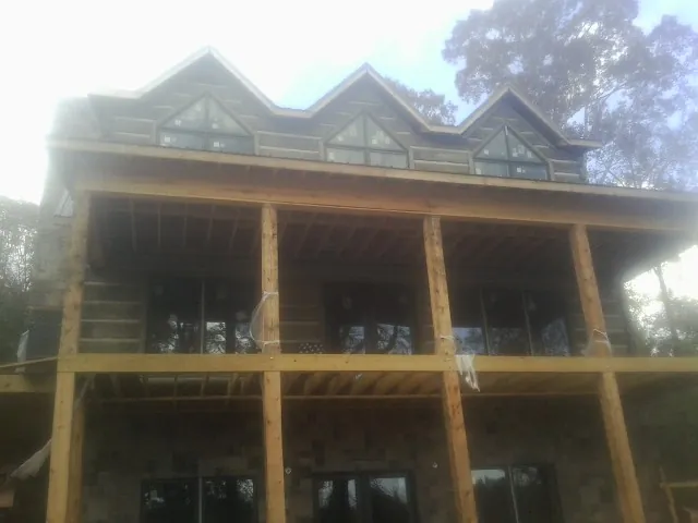 Dormers and porch framing on a large log home under construction — Roof Coating work by our crew in Fort Rock