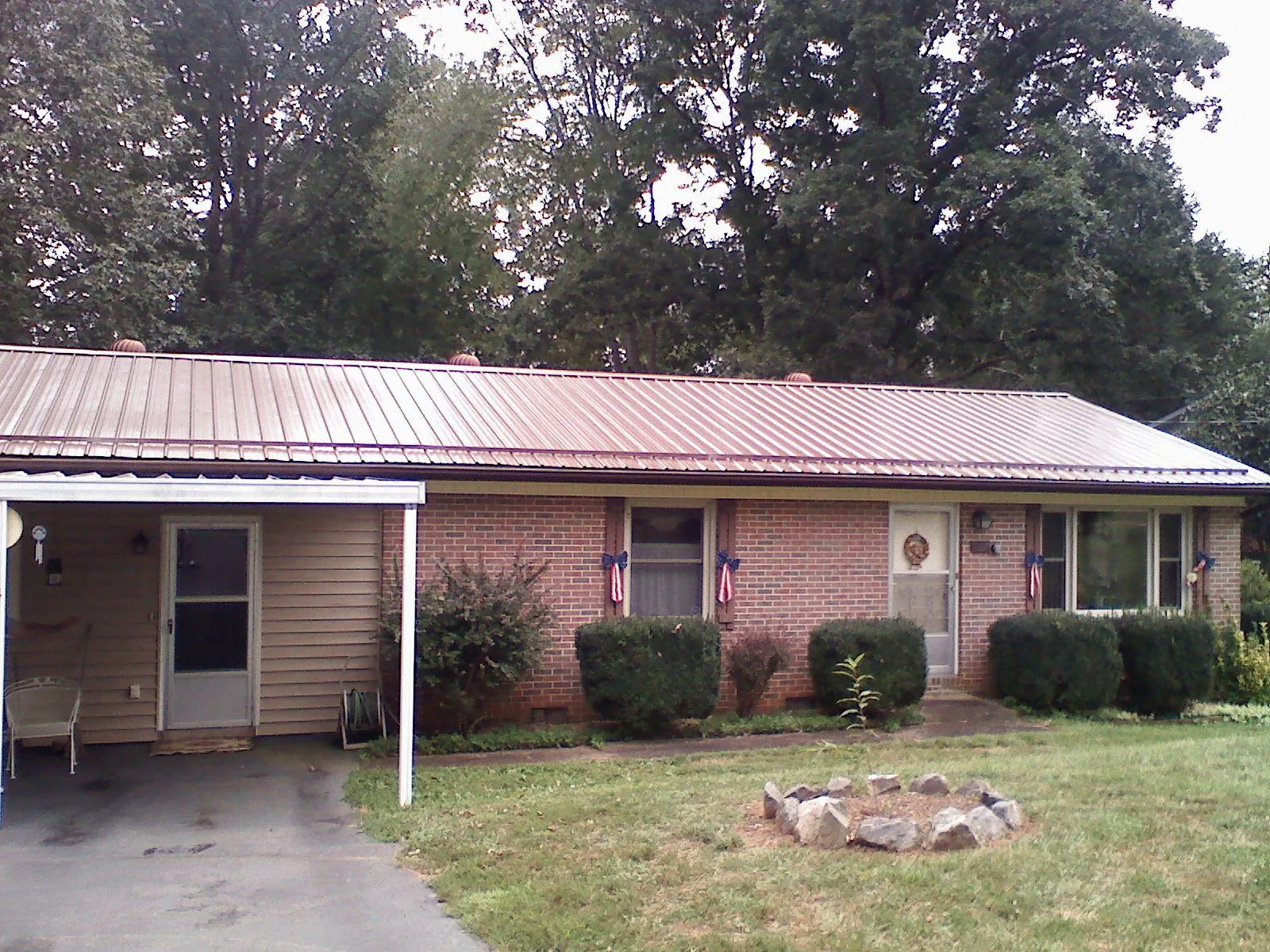 Bronze metal roof and carport on a brick ranch home — Roof Repair work by our crew in Fort Rock